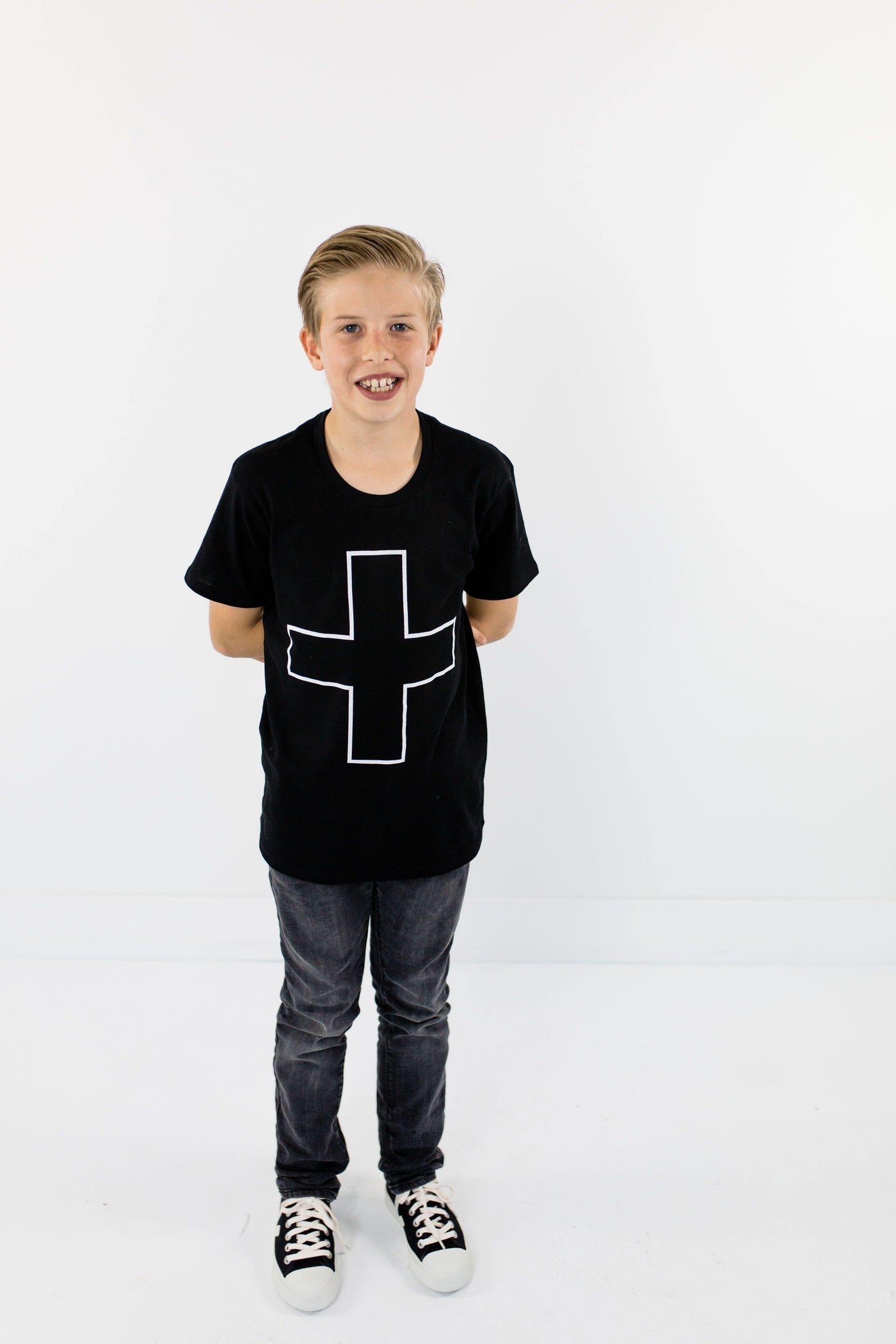 Boy wearing organic cotton black t-shirt with printed design. 