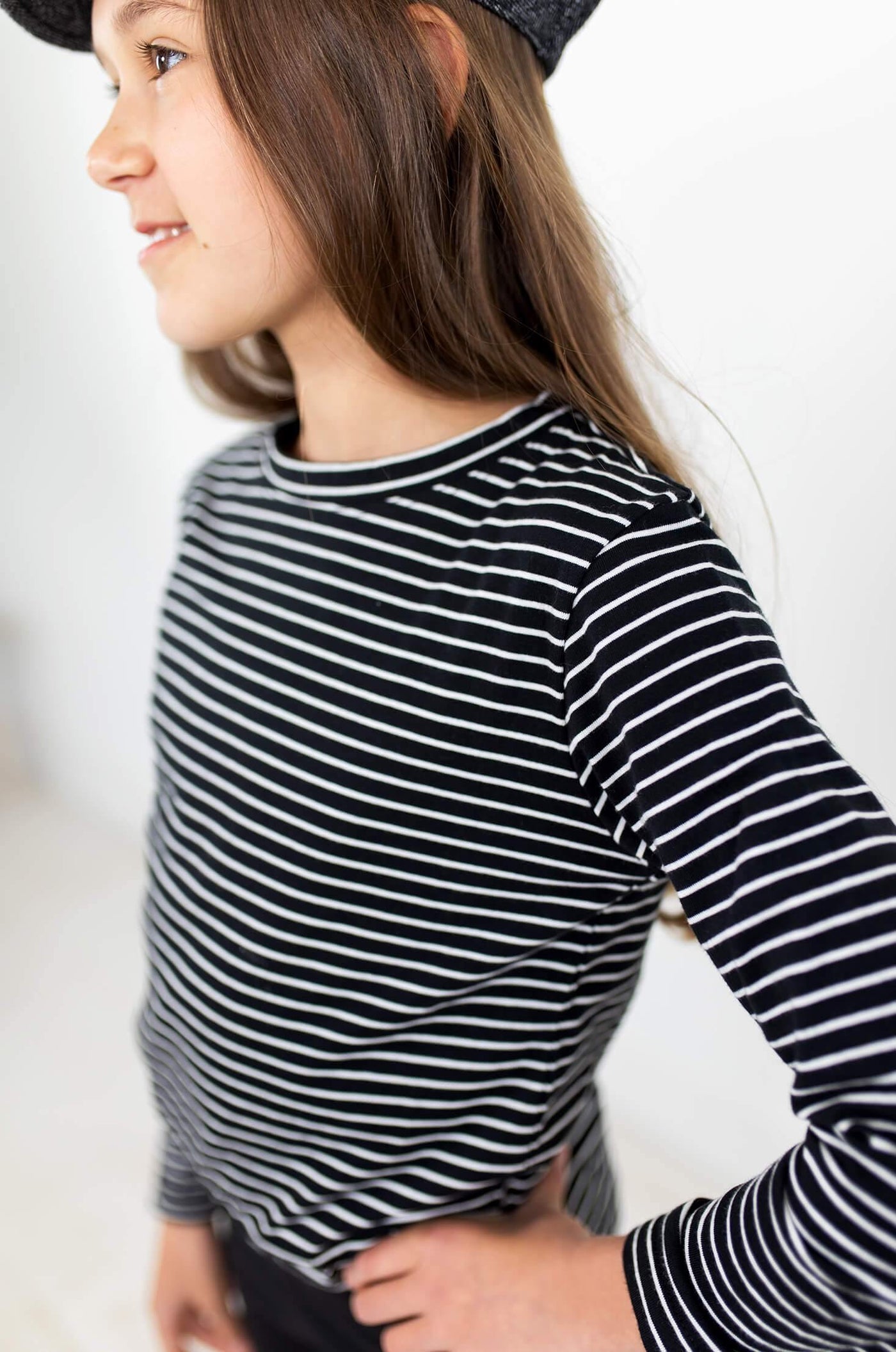 Girl wearing black and white stripe long sleeve shirt.  Ethically made with organic cotton.