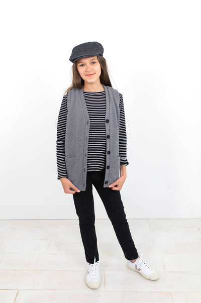 Girl wearing grey organic cotton vest with striped shirt.  Ethically made - designed in Canada.