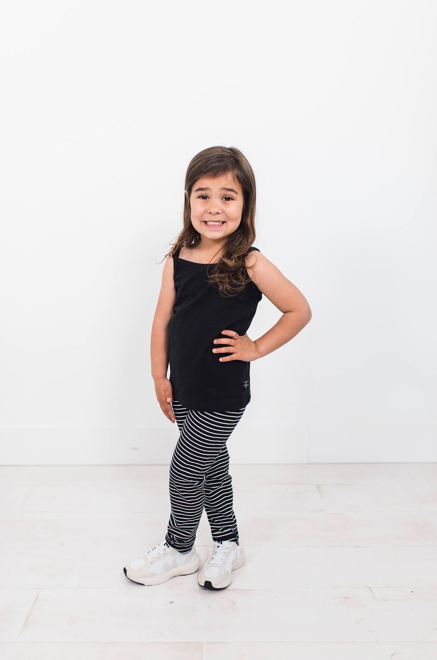 Girl wearing black and white stripe leggings with black cami.  Perfect for capsule wardrobes.
