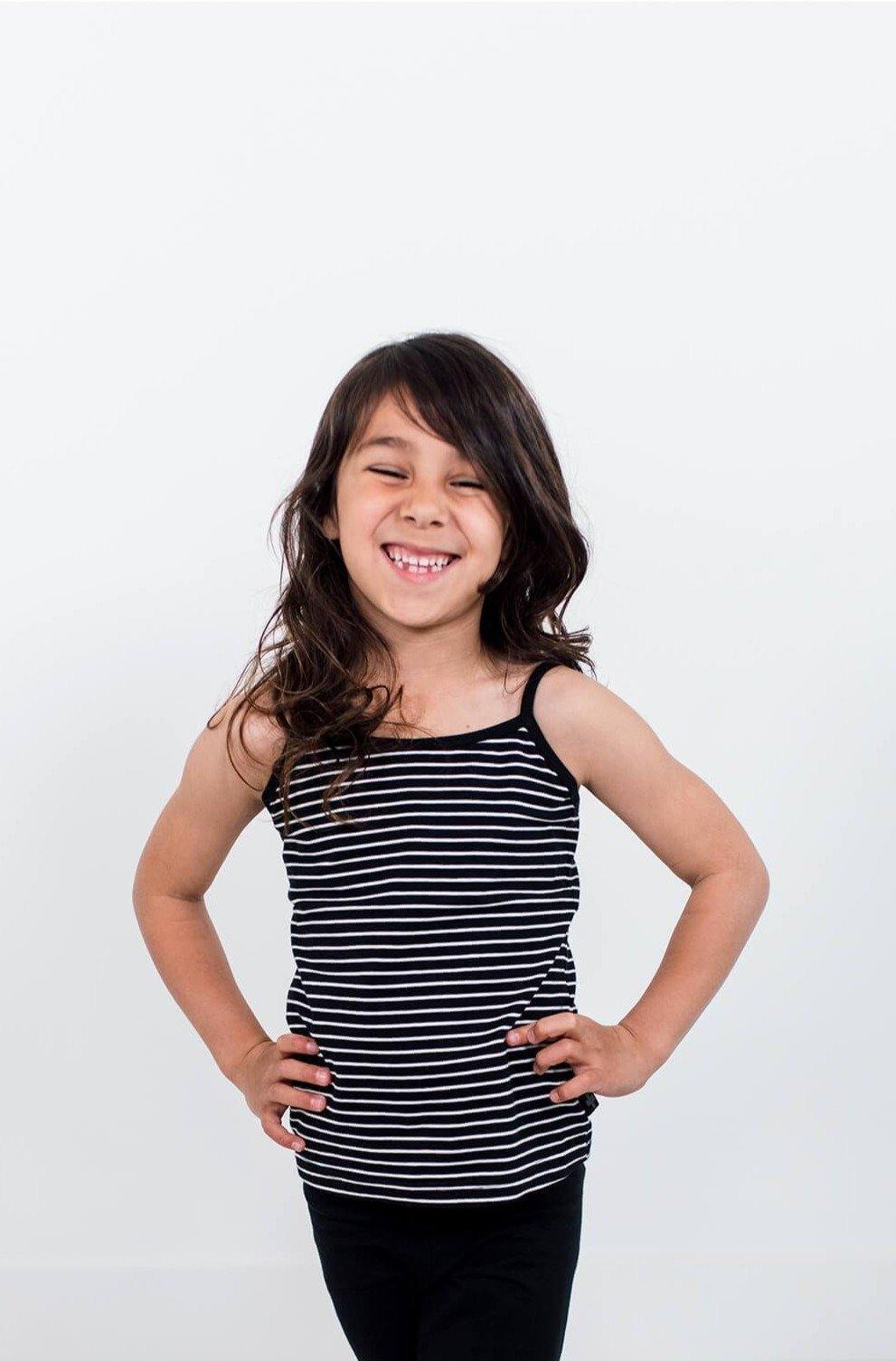 Smiling girl wearing black with white stripes cami.  Ethically made with organic cotton.