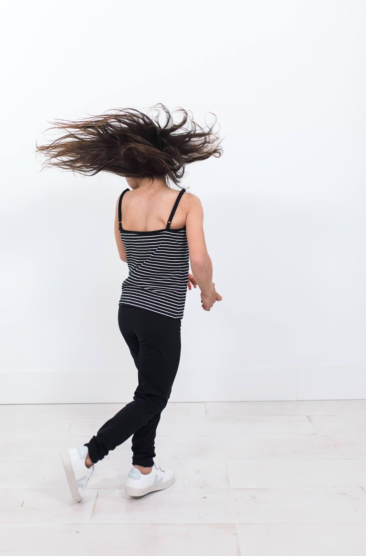 Girl twirling wearing black organic cotton leggings. 
