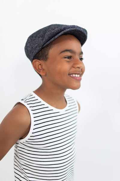 Smiling boy wearing organic cotton white tank top with black stripes.  Ethically made and designed by Author Clothing in Canada.