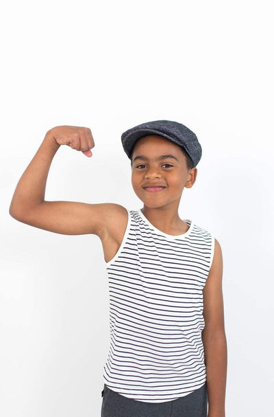 Strong boy wearing white organic cotton tank with black stripes.  Ethically made designed in Canada by Author Clothing.